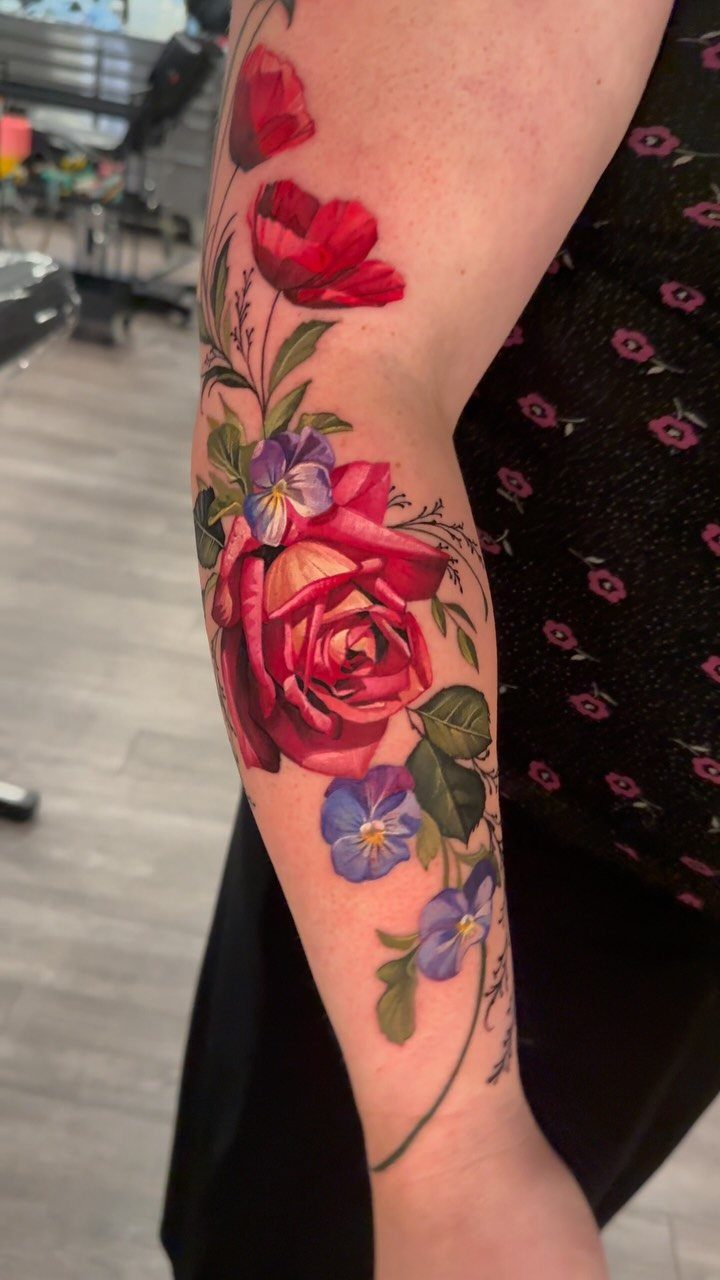 9 Side Arm Tattoos for Animals, Script, Florals and More 6 Floral tattoo on an arm featuring a red rose and purple flowers.