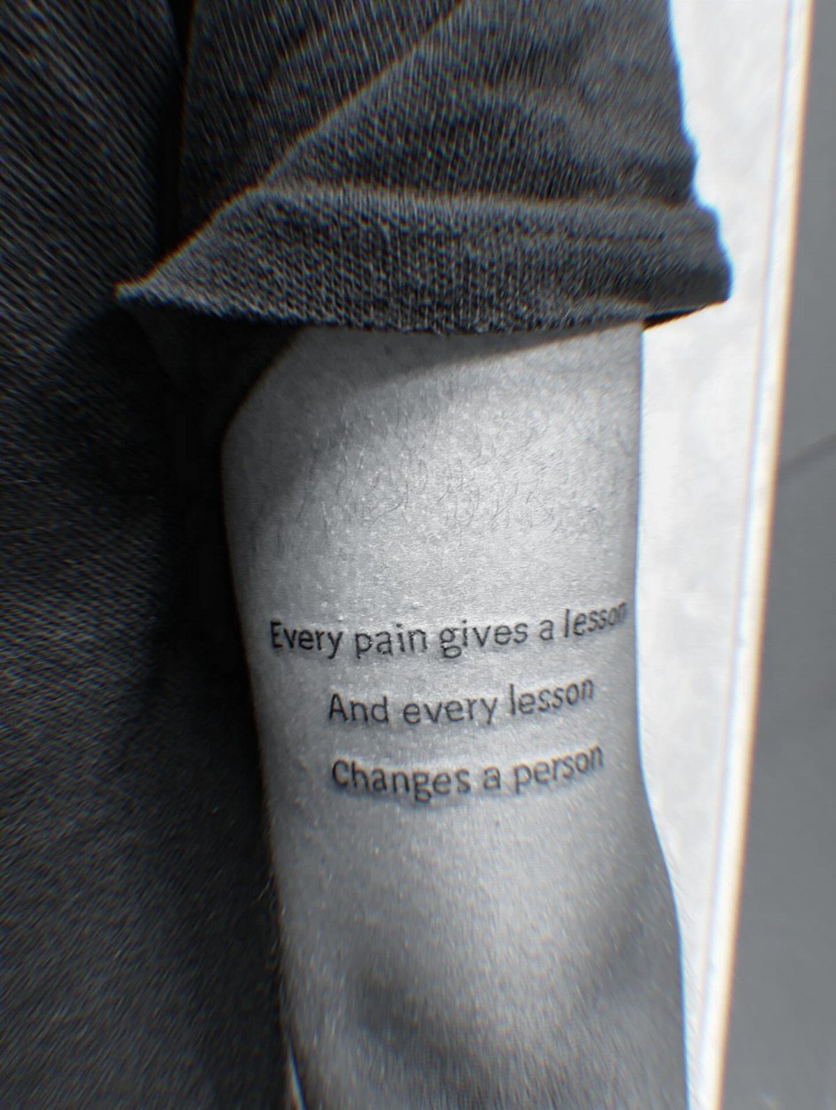 9 Side Arm Tattoos for Animals, Script, Florals and More 3 Script tattoo on an upper arm with a motivational quote about pain and lessons.