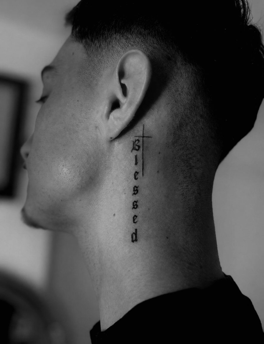 21 Side Neck Tattoo Ideas for Bold, Meaningful Designs 8 Side neck tattoo of a small cross above the word blessed in gothic script.