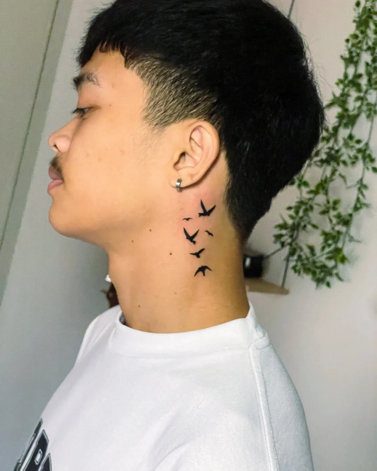 21 Side Neck Tattoo Ideas for Bold, Meaningful Designs 19 Side neck tattoo of small black birds flying upwards on a person