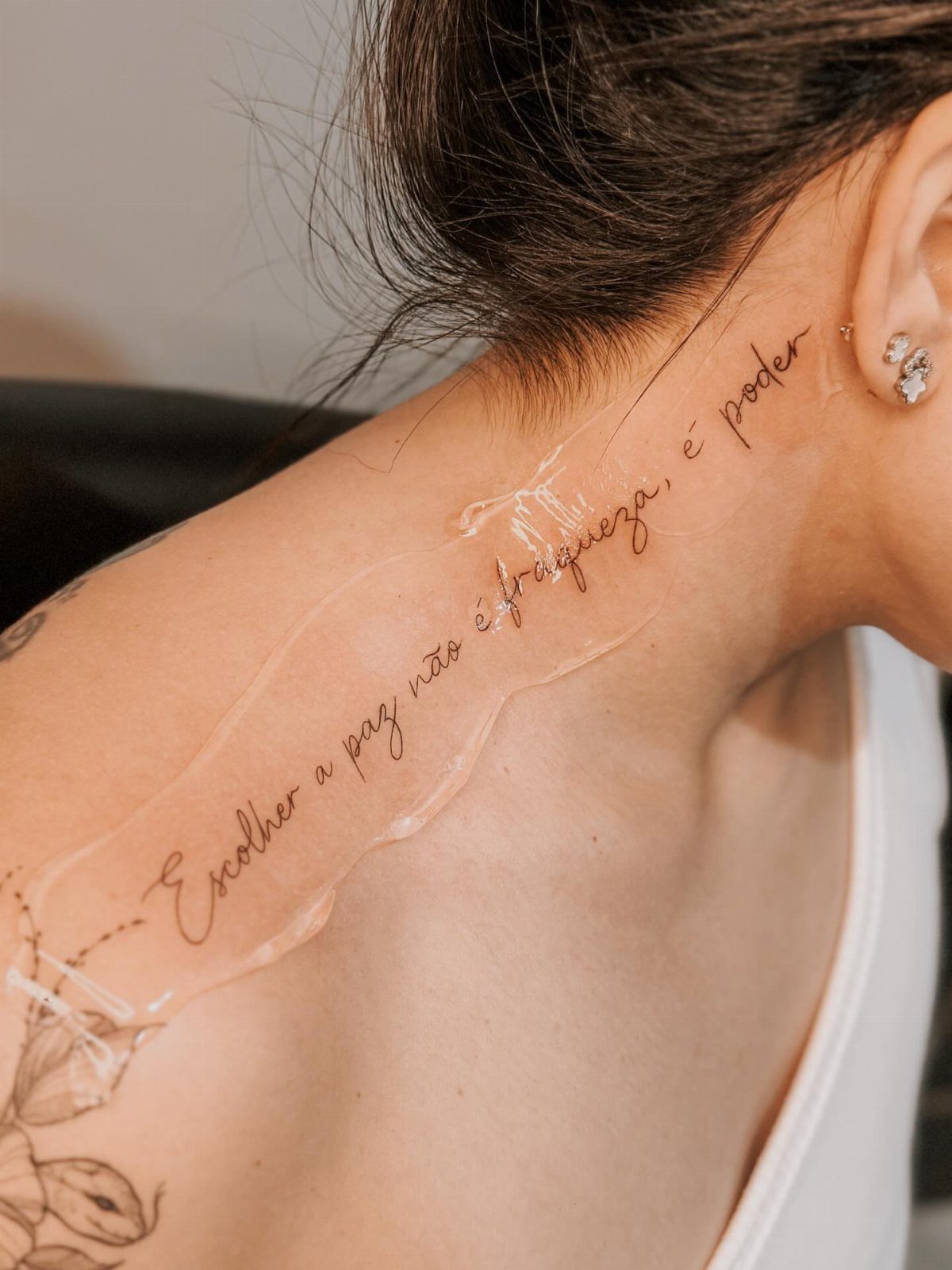 21 Side Neck Tattoo Ideas for Bold, Meaningful Designs 14 Cursive quote tattoo on a person's side neck partially covered by clear bandage.