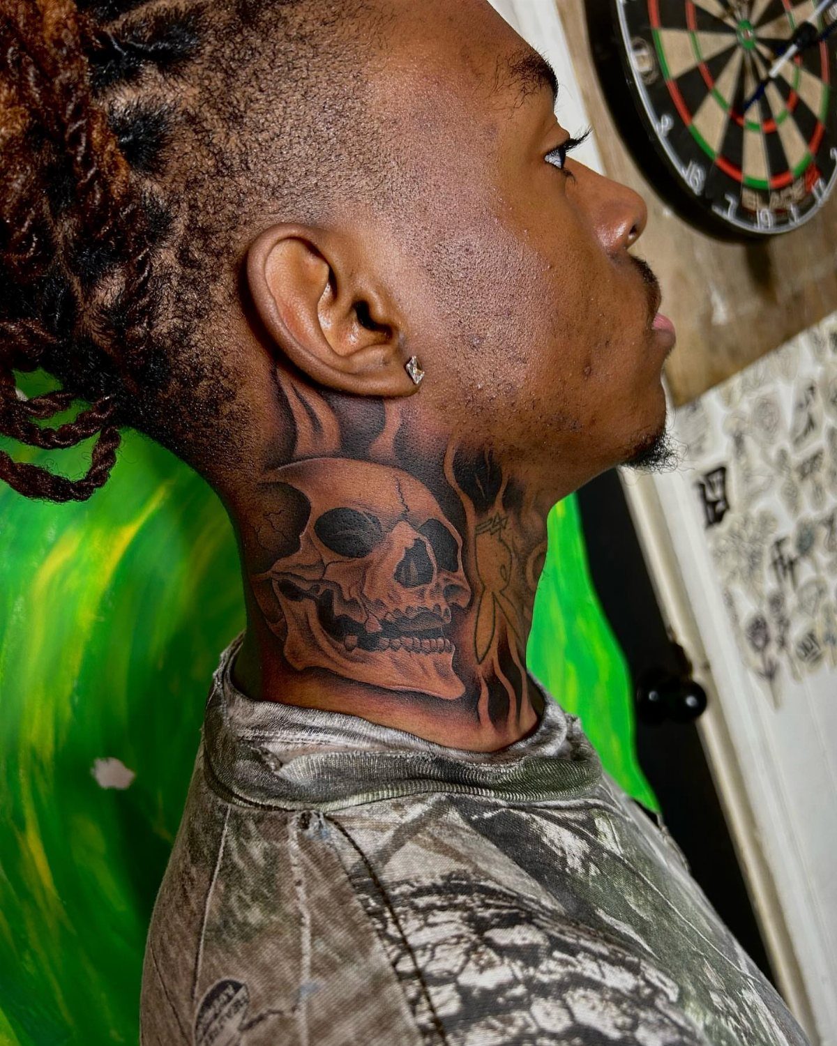 21 Side Neck Tattoo Ideas for Bold, Meaningful Designs 4 Detailed skull tattoo on the side of a person's neck with braided hair.
