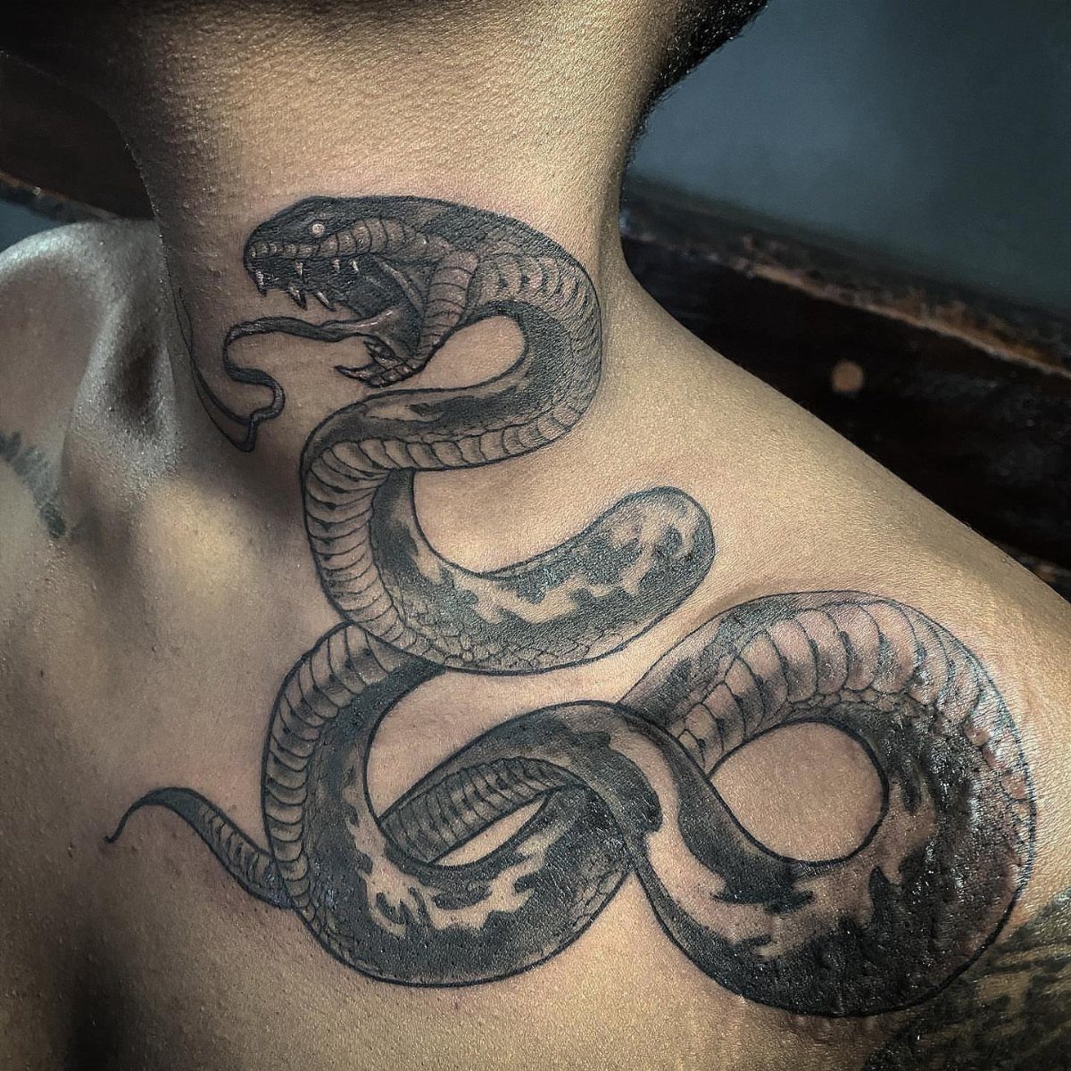 21 Side Neck Tattoo Ideas for Bold, Meaningful Designs 10 Snake tattoo winding from the side of a person's neck down to the shoulder.
