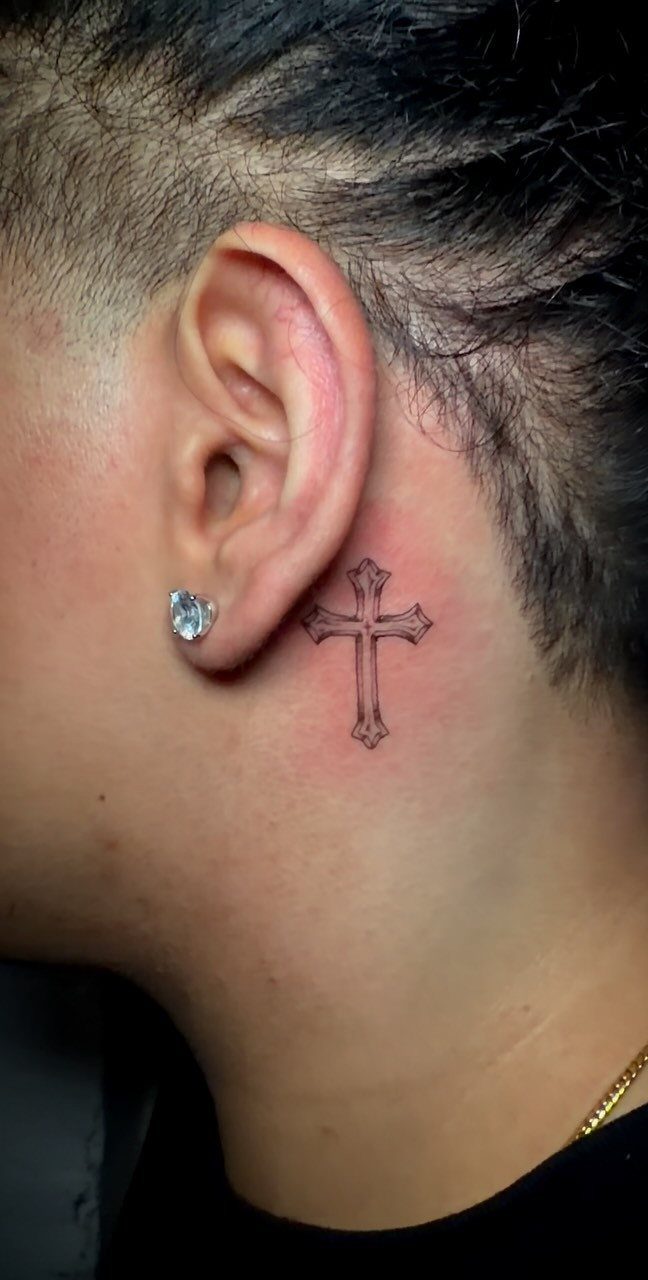 26 Small Pretty Tattoos for Butterflies, Stars, and More 24 Small black ink cross tattoo located on the neck behind the ear.