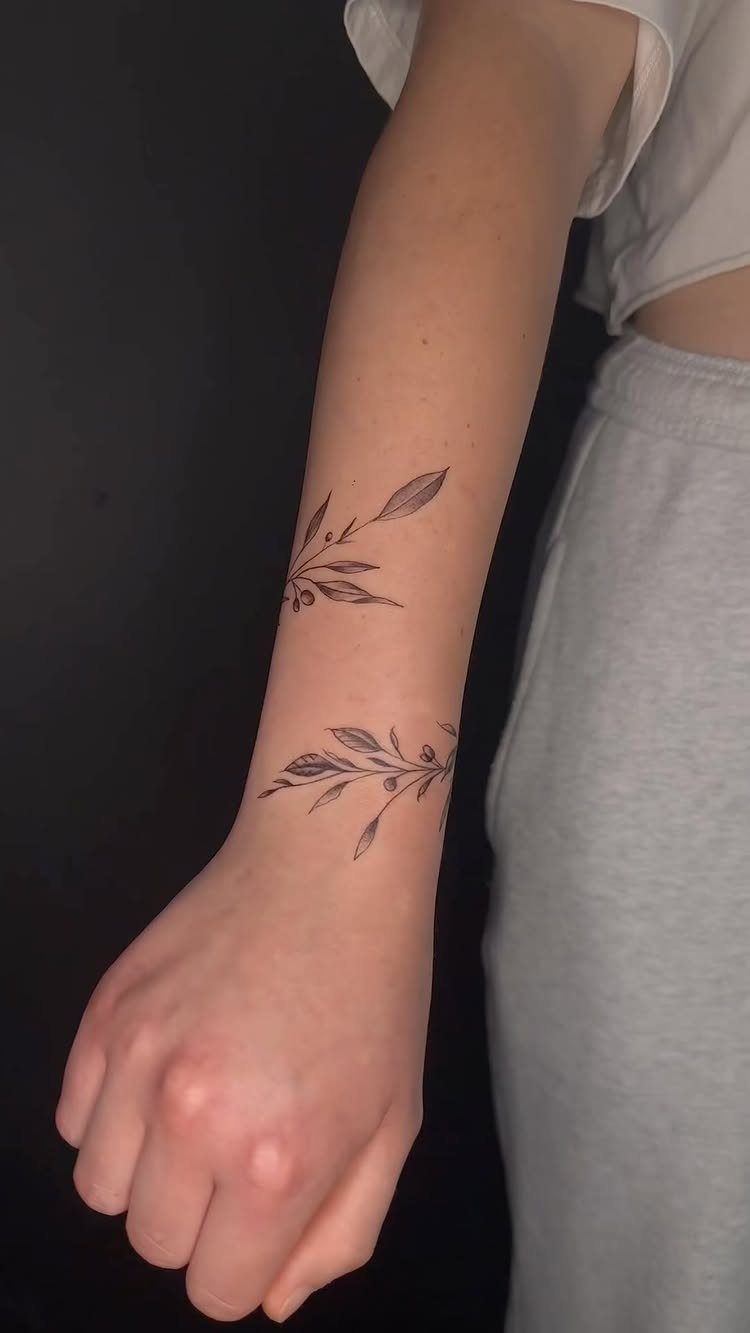 26 Small Pretty Tattoos for Butterflies, Stars, and More 19 Two small black ink olive branch tattoos on a person's inner forearm.