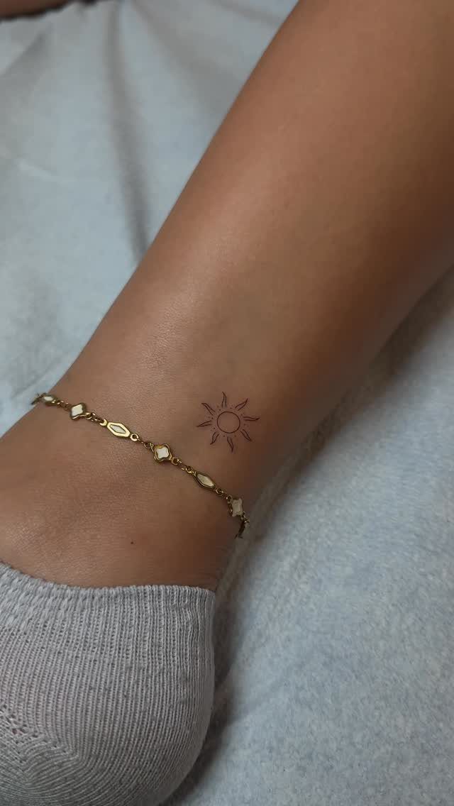 26 Small Pretty Tattoos for Butterflies, Stars, and More 13 Small sun tattoo on an ankle next to a gold chain bracelet