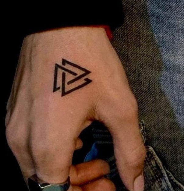 26 Small Pretty Tattoos for Butterflies, Stars, and More 8 Interlocking black triangle tattoo on the back of a person's hand