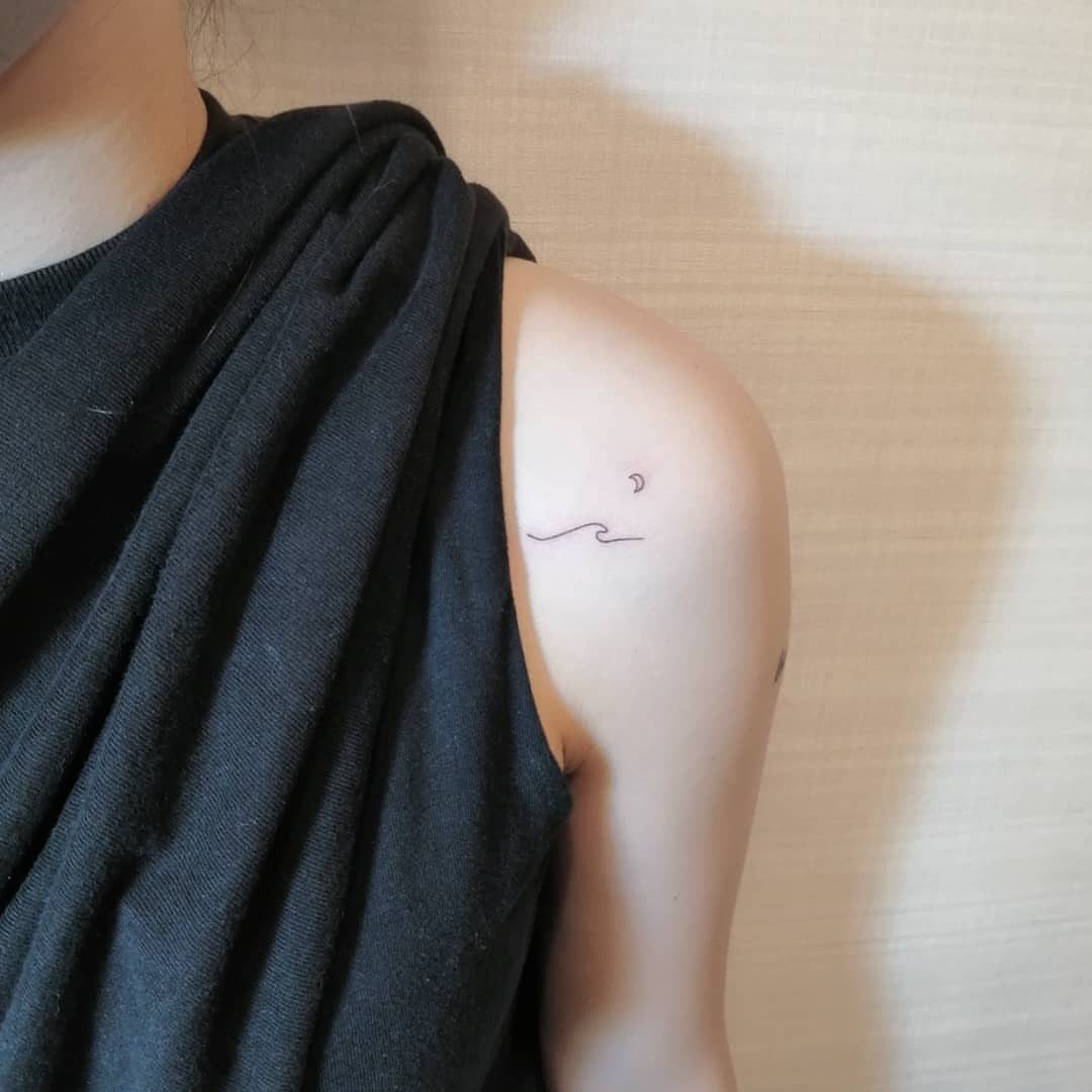 26 Small Pretty Tattoos for Butterflies, Stars, and More 22 Small fine-line wave and crescent moon tattoos on a person's shoulder