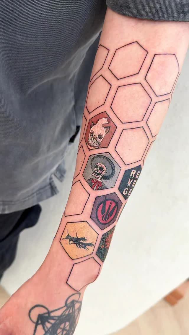 Honeycomb grid tattoo on a forearm with small colorful illustrations inside hexagons