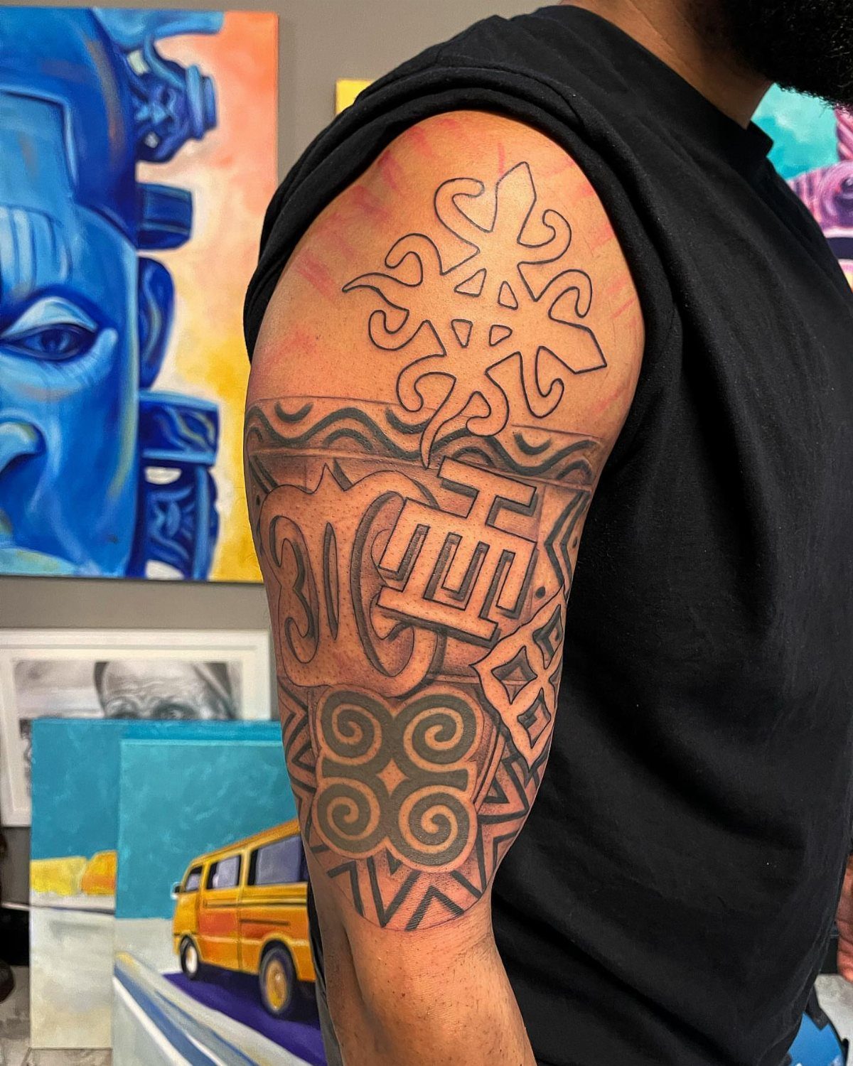 Tribal tattoos on a person's upper arm featuring various geometric symbols and patterns.