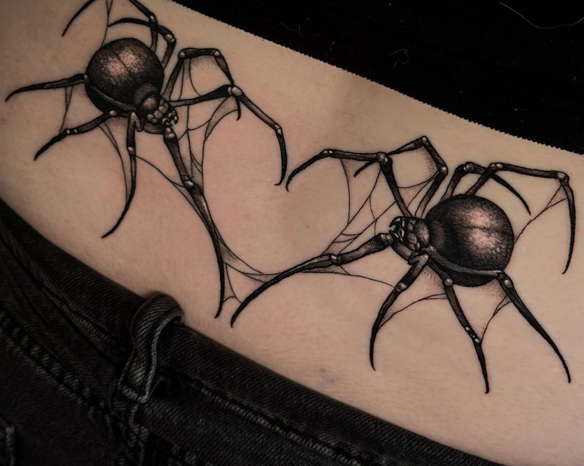 Two realistic black spider tattoos with thin webs on a person's stomach