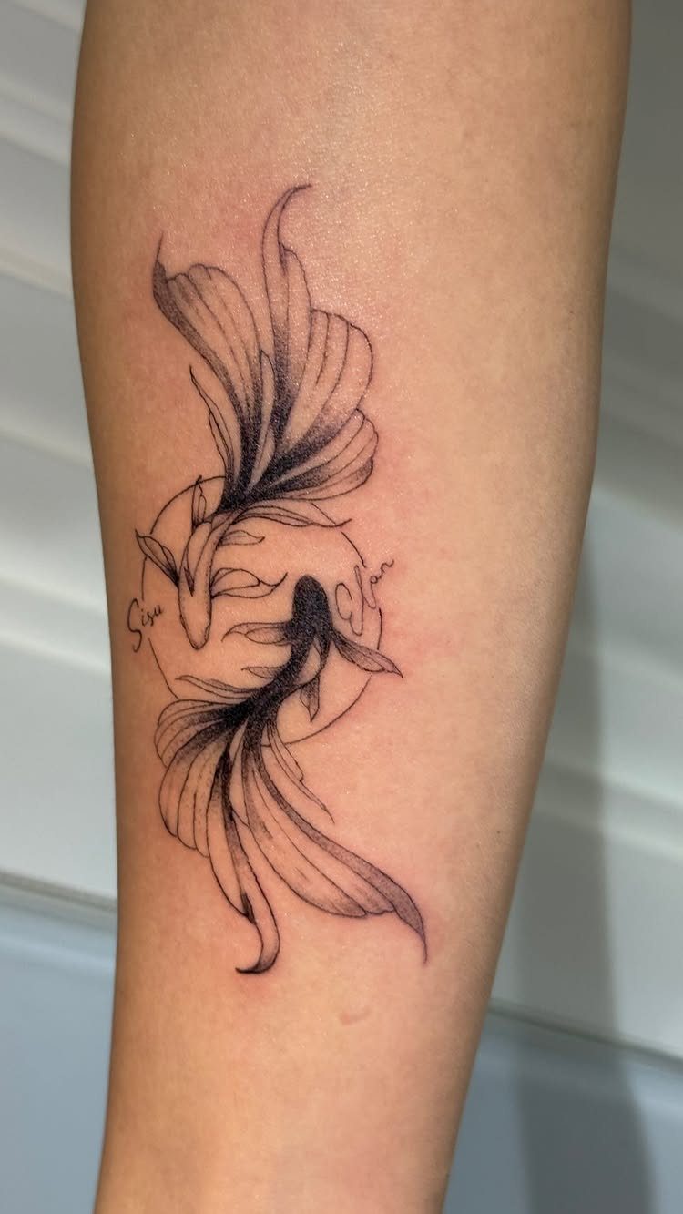 Koi fish tattoo on an arm forming a circular yin yang symbol