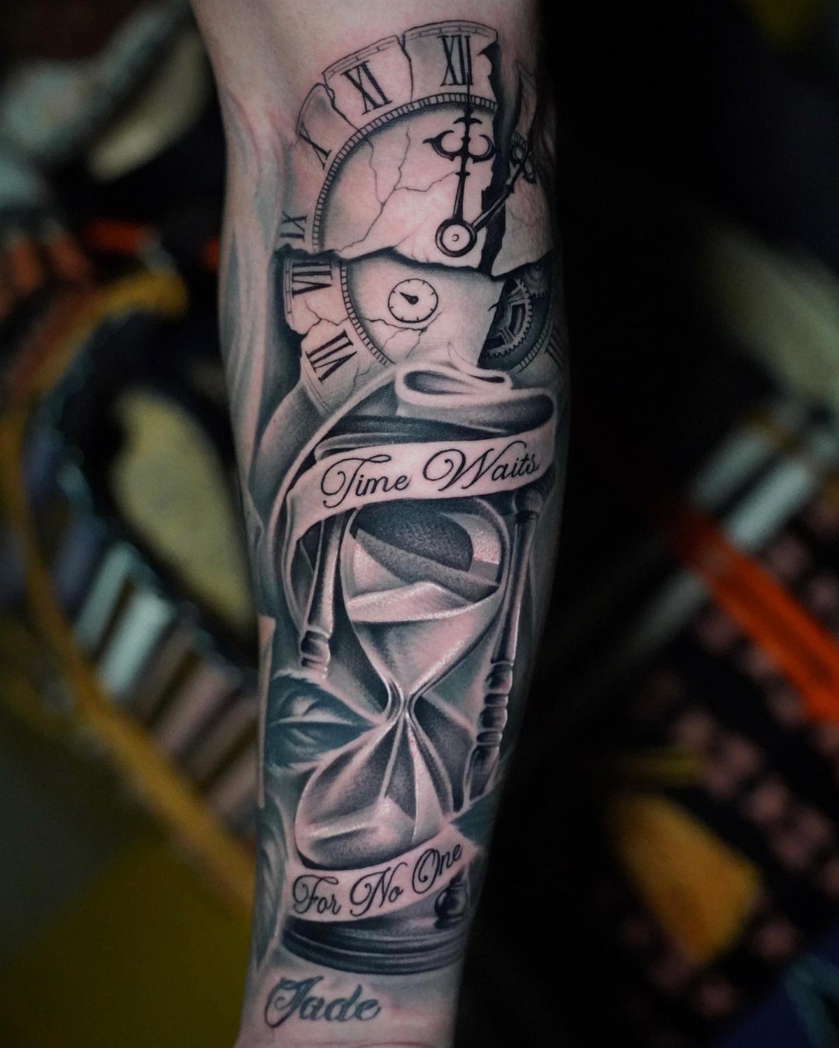 Tattoo of a cracked clock and hourglass with Time Waits For No One text.
