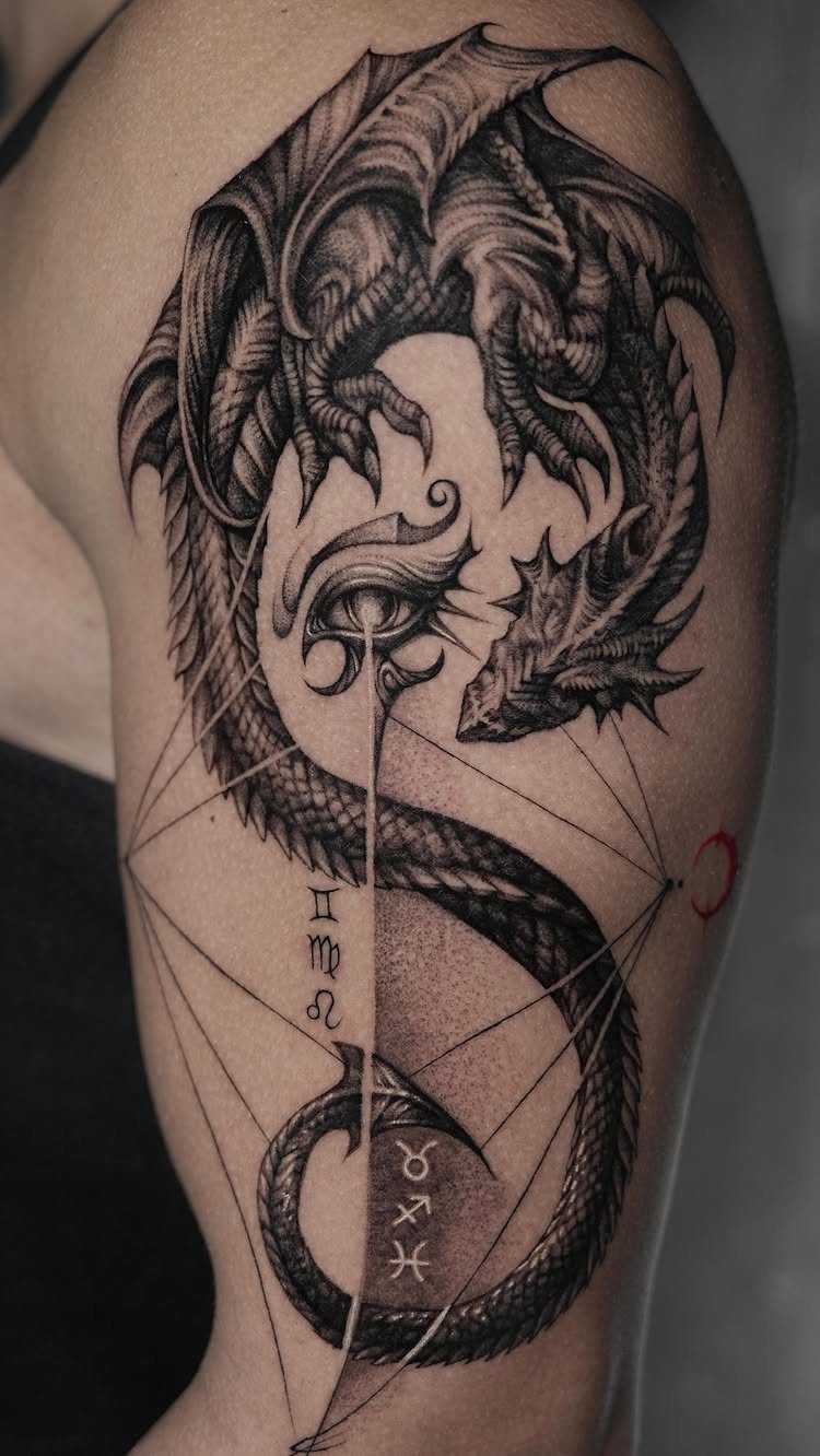 Detailed black ink dragon tattoo with geometric lines and symbols on an arm.