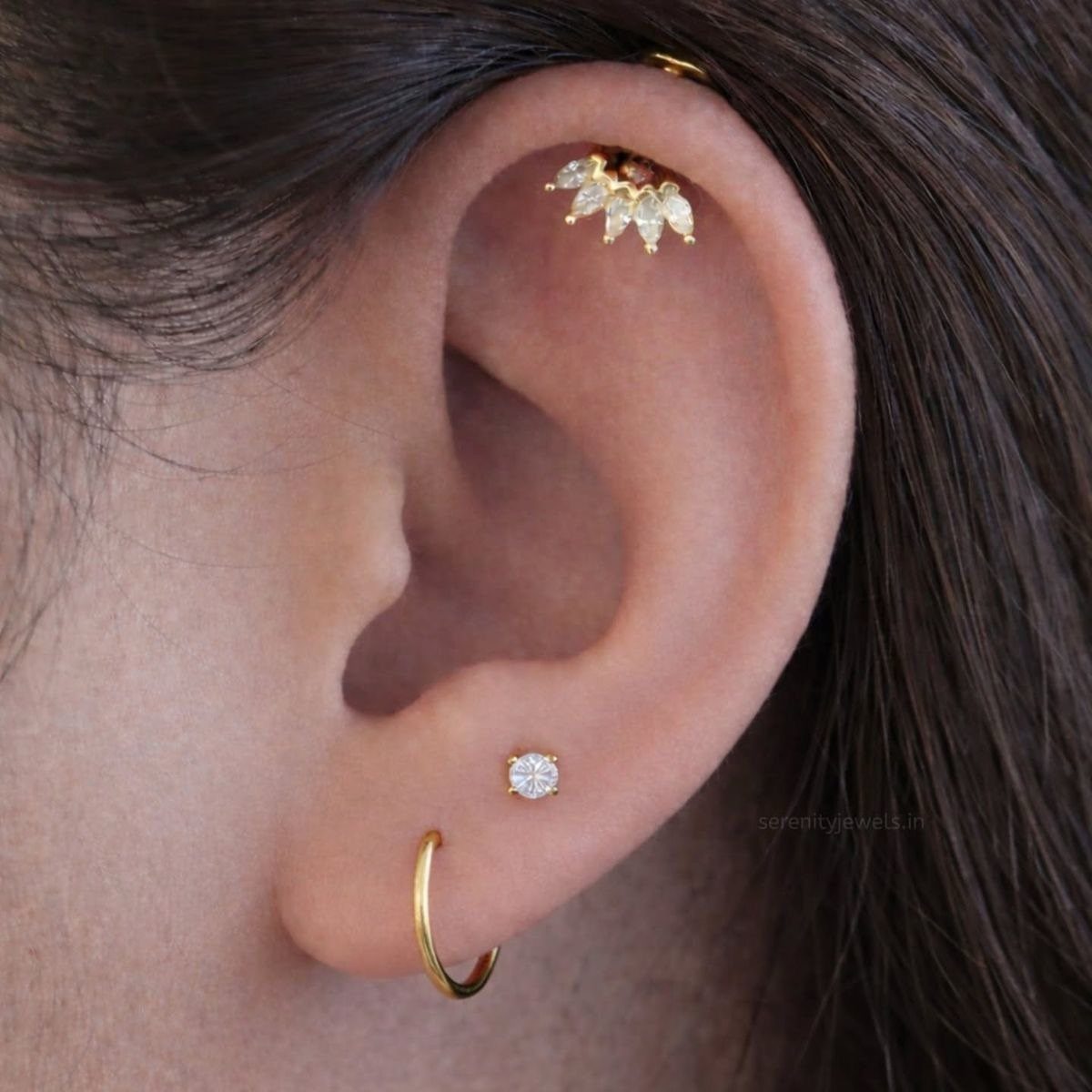 9 Upper Cartilage Piercing Ideas, Jewelry, and Aftercare 6 Ear with a gold leaf stud in the upper cartilage and lobe piercings.