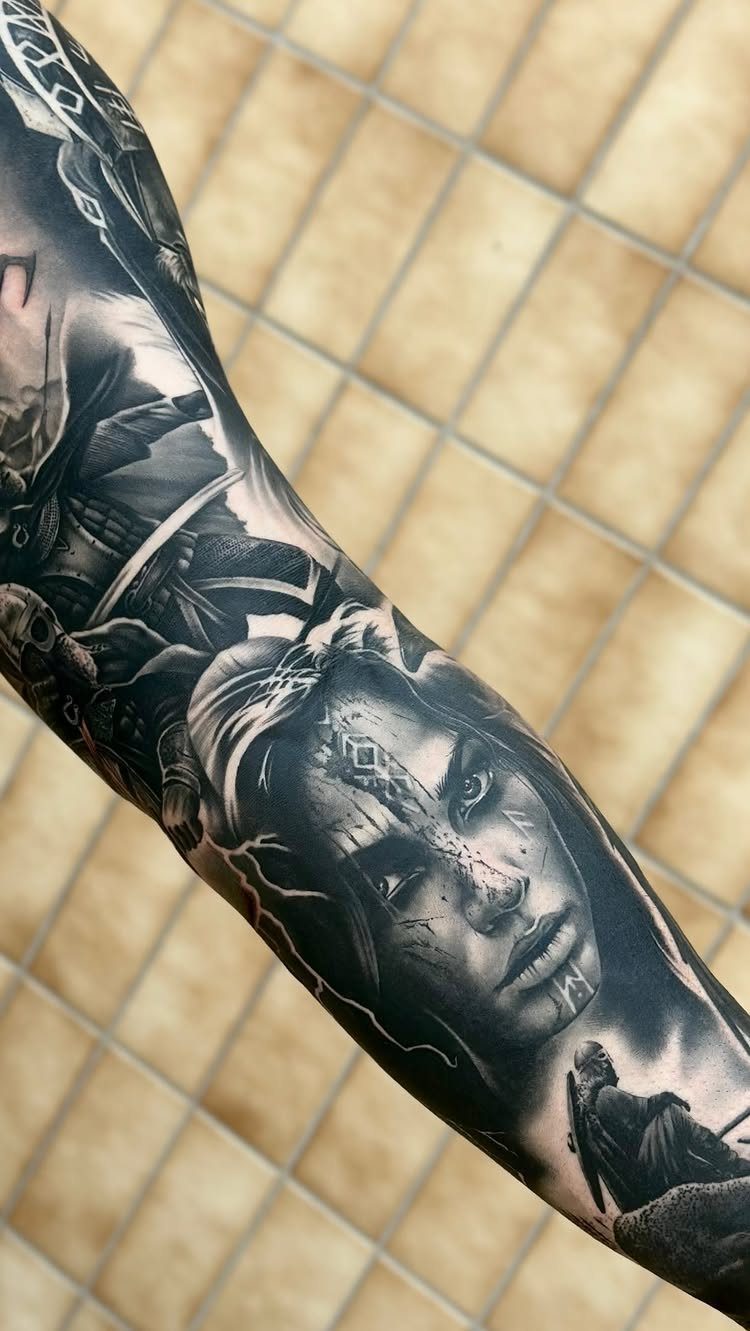 Female warrior tattoo in black and grey realism on a person's arm.