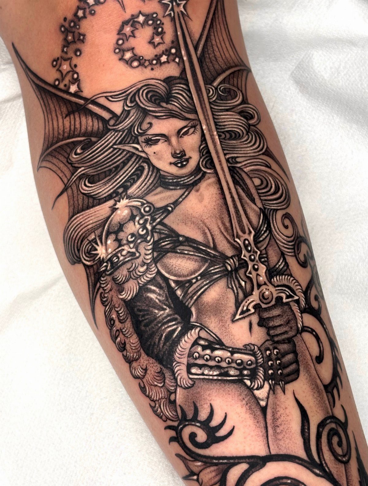 Female elf warrior tattoo with ornate armor and sword on a person's arm
