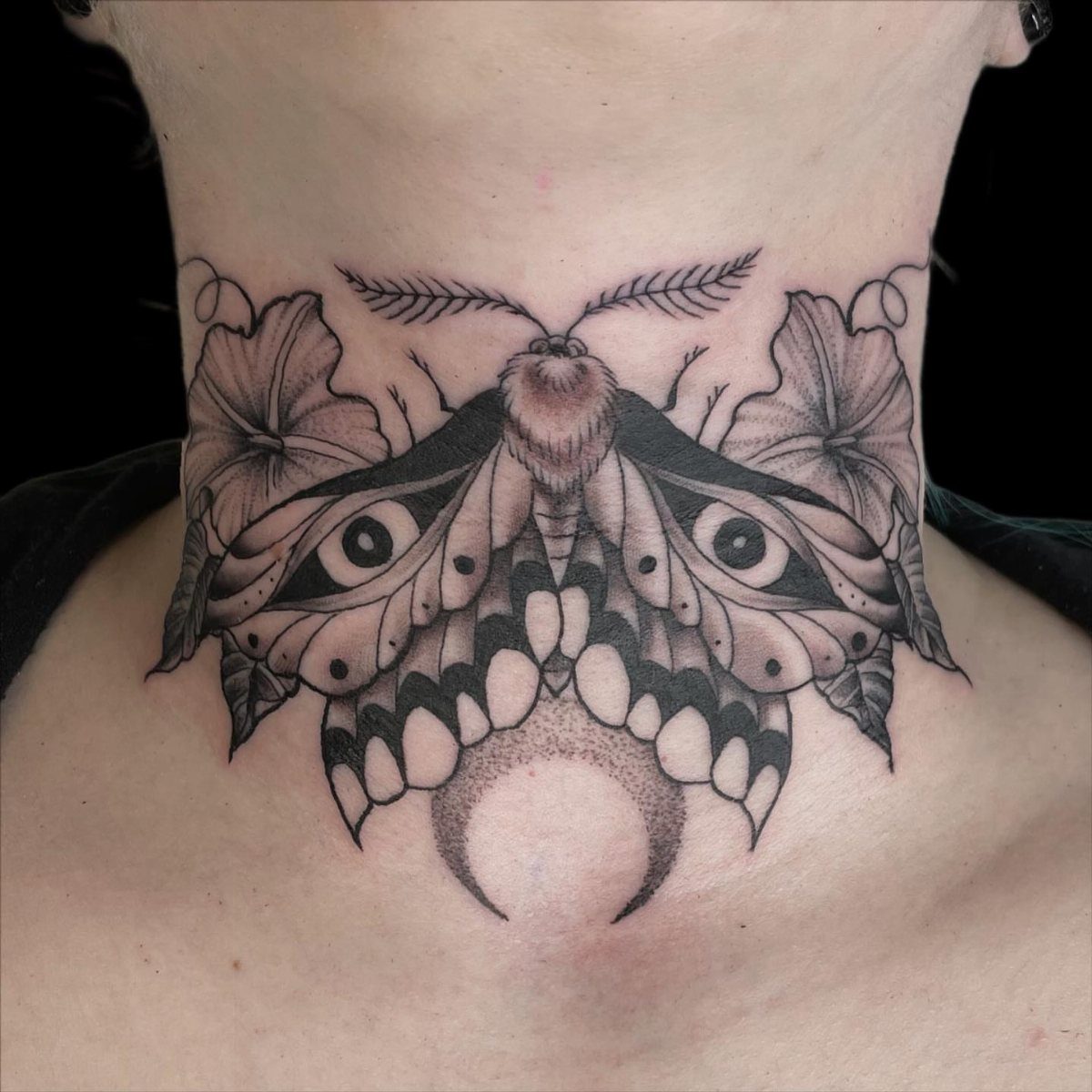5 Witchy Neck Tattoos for Moon, Moth and Raven Lovers 4 Moth tattoo with eye patterns and crescent moon on a person's neck.